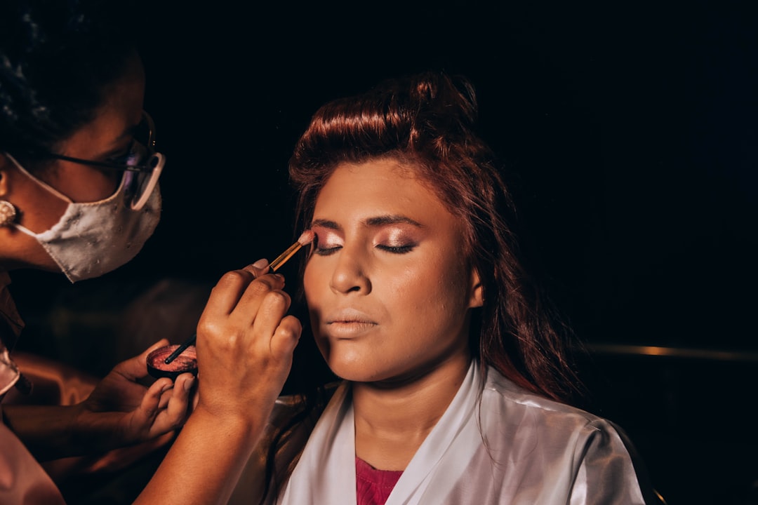 A makeup artist is applying eyeshadow to a client.